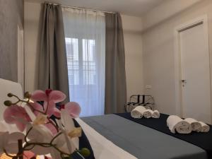 sypialnia z łóżkiem z ręcznikami i oknem w obiekcie Little Rose Haven w Rzymie