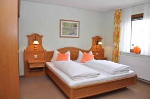 a bedroom with two beds with orange pillows at Landhotel Zur Pferdetränke in Schleid