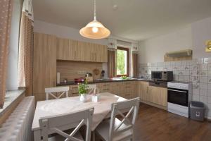 a kitchen with a table and chairs in a kitchen at Landhotel Zur Pferdetränke in Schleid