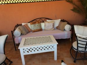 un letto con cuscini e un tavolo in una stanza di Riad Irene a Marrakech
