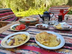 a picnic table with plates of food on it at Sleep In Siwa in Siwa