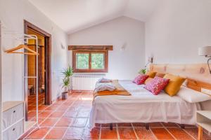 ein Schlafzimmer mit einem Bett mit Kissen darauf in der Unterkunft Masia Ventanell Luxury villa near Barcelona in Llacuna