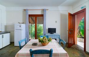 a kitchen with a table and chairs and a television at Giola Bungalows Sirines in Astris