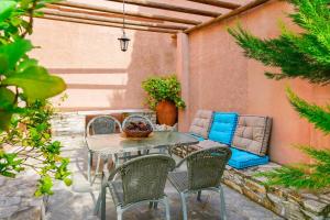a patio with a table and chairs and a couch at Giola Bungalows Sirines in Astris