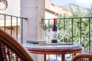 a bottle of wine and two glasses on a table at Ca Na Bel in Port de Soller