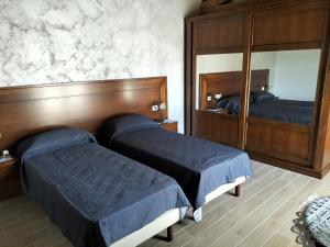 - une chambre avec 2 lits et un grand miroir dans l'établissement Agriturismo Dipinto Dal Sole, à Padula