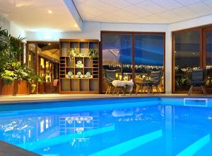 a swimming pool in a house with a dining room at Hotel Schaepkens van St Fijt in Valkenburg