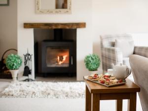 a living room with a tray of food on a table with a fireplace at Teagles Cottage in Stow, EV parking in Stow on the Wold +16 photos