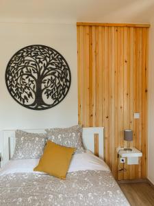 1 dormitorio con 1 cama con una foto de árbol en la pared en Casa das Laranjeiras, en Alfarim