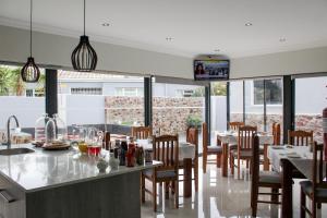 a dining room with tables and chairs and a television at Elizabeth House in Hermanus