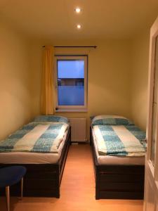 two beds in a small room with a window at Gemütliche 3 Zimmer Wohnung in Frauenhofen