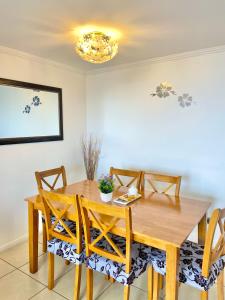a dining room with a wooden table and chairs at Apartamentos Alma Socoroma in Arica +35 photos