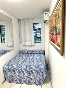 ein kleines Schlafzimmer mit einem Bett und zwei Fenstern in der Unterkunft Flat Marulhos Resort in Porto De Galinhas