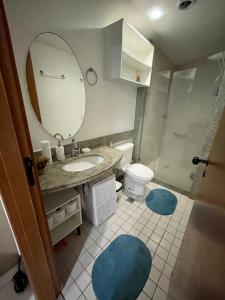 ein Badezimmer mit Waschbecken, Toilette und Spiegel in der Unterkunft Flat Marulhos Resort in Porto De Galinhas