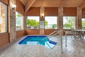 a swimming pool in a house with a table and chairs at Rodeway Inn Coopersville in Coopersville