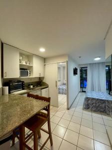 eine Küche und ein Wohnzimmer mit einem Bett in einem Zimmer in der Unterkunft Flat Marulhos Resort in Porto De Galinhas