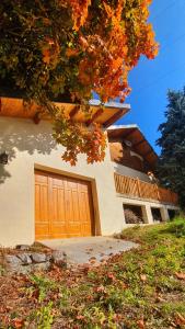 une maison avec une porte de garage en bois devant elle dans l'établissement Magnifique Chalet avec Balnéothérapie, à Roubion