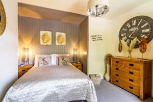 a bedroom with a bed and a large clock on the wall at River View, Stamford Bridge in Stamford Bridge