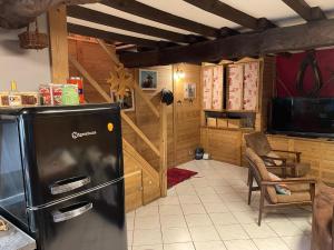 eine Küche mit einem schwarzen Kühlschrank im Zimmer in der Unterkunft Grange rénovée, Pyrénées Ariégeoises, Gîte haute Ariège in Auzat