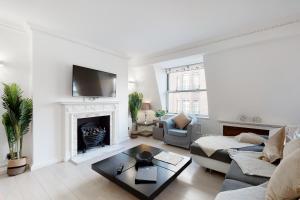 a living room with a couch and a fireplace at Stay in bond street in London