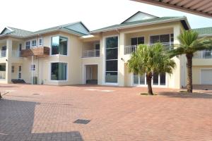 una casa con dos palmeras en una entrada en Golf Course Boutique Guesthouse en Mount Edgecombe