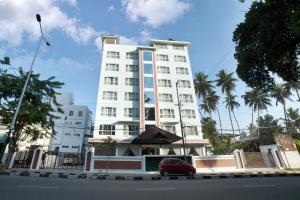 a red car parked in front of a white building at Vivin Luxury Suites in Trivandrum