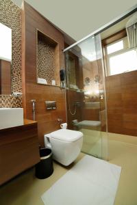 a bathroom with a toilet and a glass shower at Vivin Luxury Suites in Trivandrum