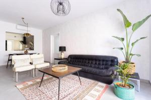 sala de estar con sofá de cuero negro y mesa en Home2Book Charming Center Apartment Santa Cruz, en Santa Cruz de Tenerife