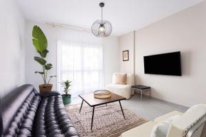 sala de estar con sofá y TV en Home2Book Charming Center Apartment Santa Cruz, en Santa Cruz de Tenerife