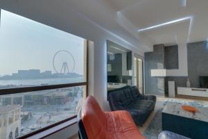 a living room with a couch and a large window at Elan Rimal 5 Suites in Dubai +63 photos