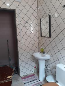 a bathroom with a sink and a mirror at Aconchegante casa para temporada in Mongaguá
