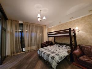 Arcadia Apartments في أوديسا: غرفة نوم بسرير وكرسي وأريكة