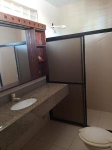 a bathroom with a toilet and a sink and a mirror at Casa de Praia Pecém in São Gonçalo do Amarante
