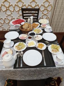 a table with plates of food on it at Muhtasham Hotel in Ichan Qala in Khiva