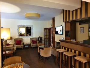 - un salon avec une table, des chaises et un bar dans l'établissement Hotel Verde Pinho Bed&Breakfast, à São Pedro de Muel