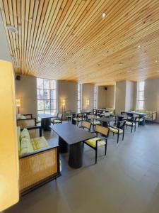 a dining room with tables and chairs and windows at Chospa Hotel, Leh in Leh