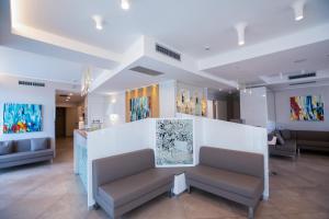 a waiting room with chairs and paintings on the walls at Hotel Baby in Rimini