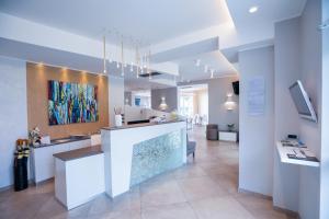 a lobby with a counter and a painting on the wall at Hotel Baby in Rimini