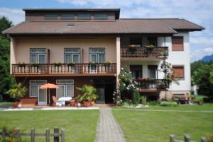 una casa con balcone e prato di Ferienhaus Michor a Latschach ober dem Faakersee