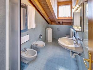 een badkamer met 2 wastafels en een toilet bij Hotel Piccolo Pocol in Cortina dʼAmpezzo
