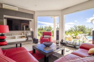 ル・ラヴァンドゥーにあるVilla Lili Roseのリビングルーム(赤い家具、大きな窓付)