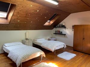 two beds in a room with wooden ceilings at Casa Madonnina in Losone