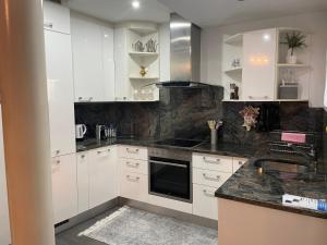 a kitchen with white cabinets and black counter tops at Casa Madonnina in Losone