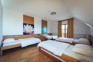 a bedroom with four beds and a large window at Pohorje Village Wellbeing Resort - Forest Hotel Videc in Pohorje