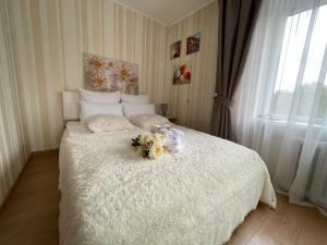 カリーニングラードにあるApartment on prospekt Leninskiyのベッドルーム1室(花が咲く白いベッド1台付)