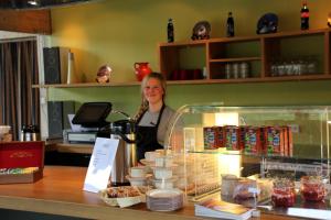 a woman standing behind a counter in a bakery at Jotunheimen Fjellstue in Boverdalen