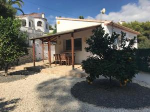 a house with an orange tree in front of it at Limon in Benissa