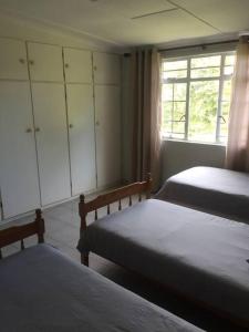 1 dormitorio con 2 camas y ventana en Meshlynn farm cottage, en Thendele