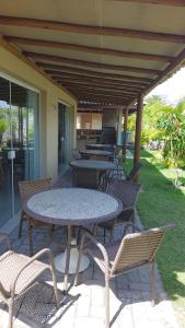 a group of tables and chairs on a patio at Residencial Verano 105C in Guarajuba