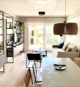 a living room with a couch and a table at Stylish Apartment by River with Pool & Grill in Olivos